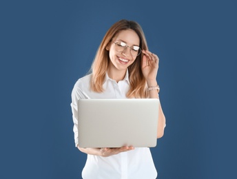 Photo of Portrait of young woman in office wear with laptop on color background