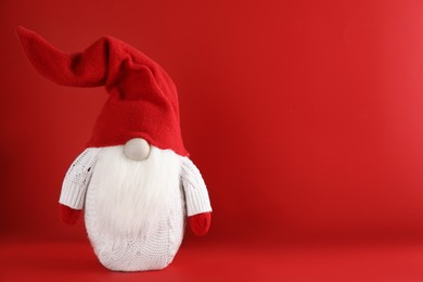 Photo of Cute Christmas gnome on red background. Space for text