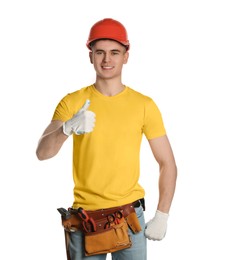 Photo of Handyman in hard hat with tool belt showing thumb up isolated on white