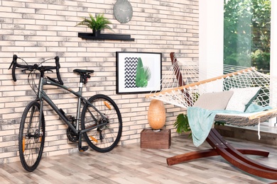 Modern bicycle and hammock in stylish room interior