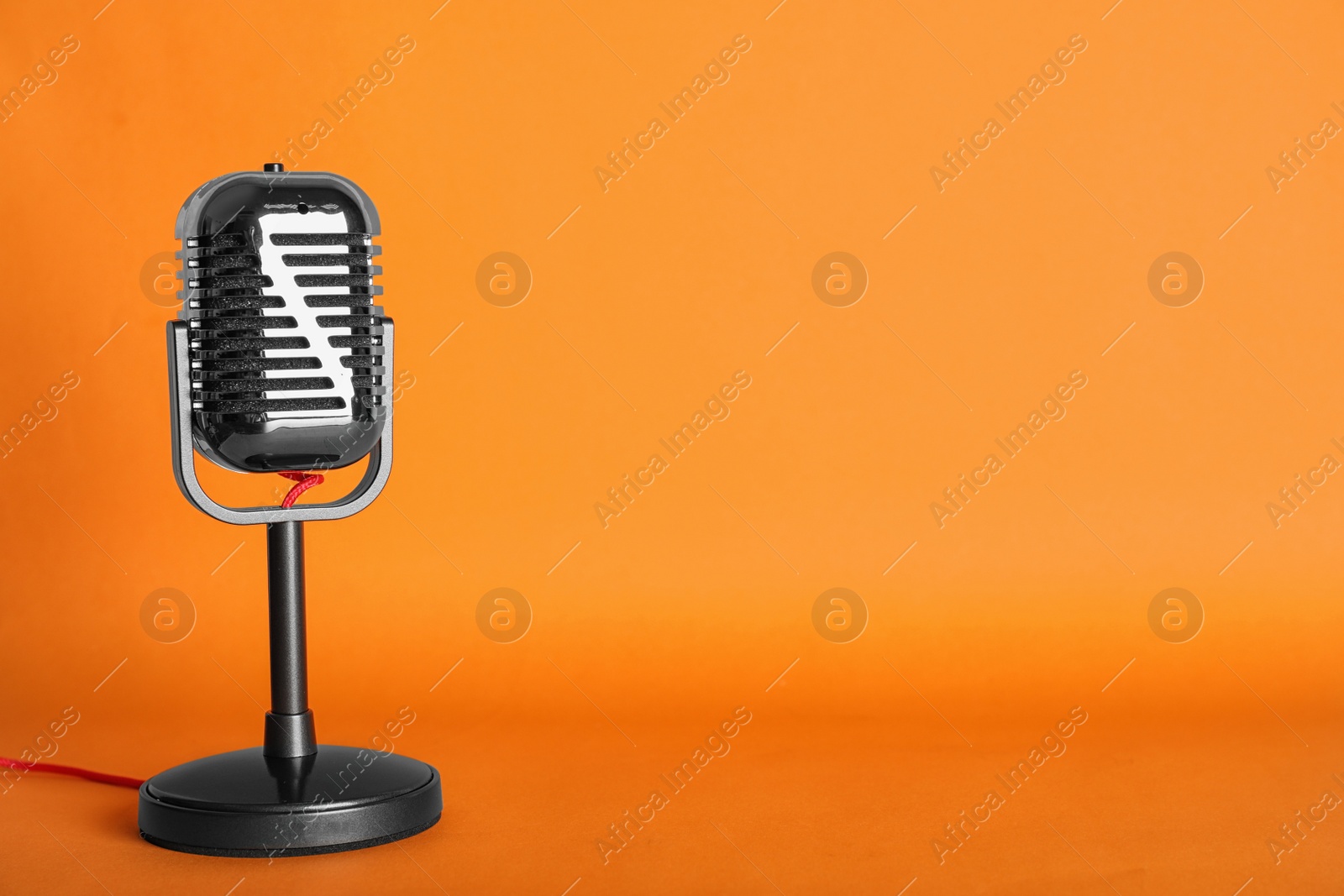 Photo of Retro microphone on color background, space for text. Musical equipment