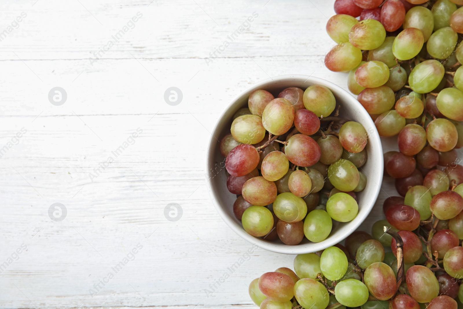 Photo of Flat lay composition with fresh ripe juicy grapes and space for text on table