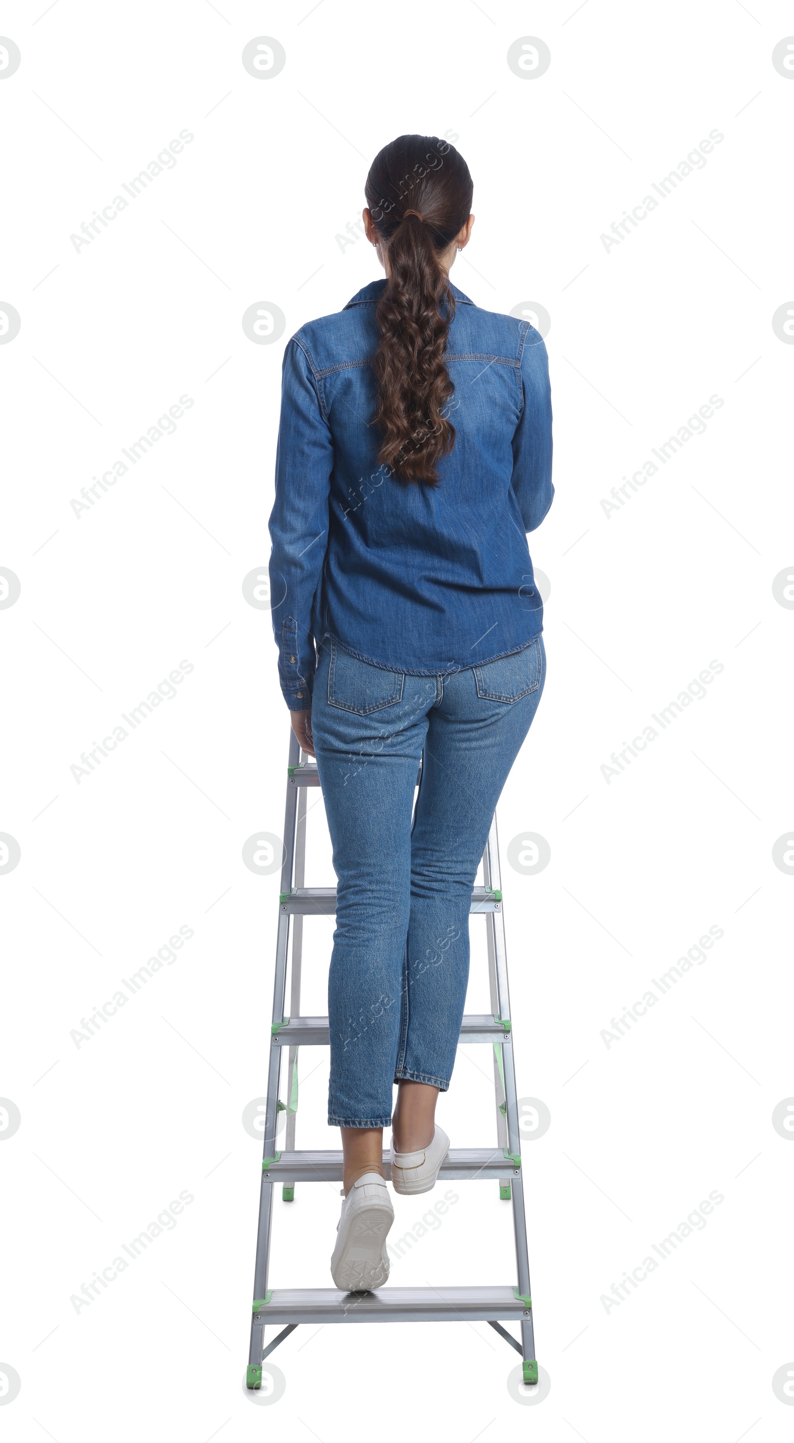 Photo of Young woman climbing up metal ladder on white background, back view