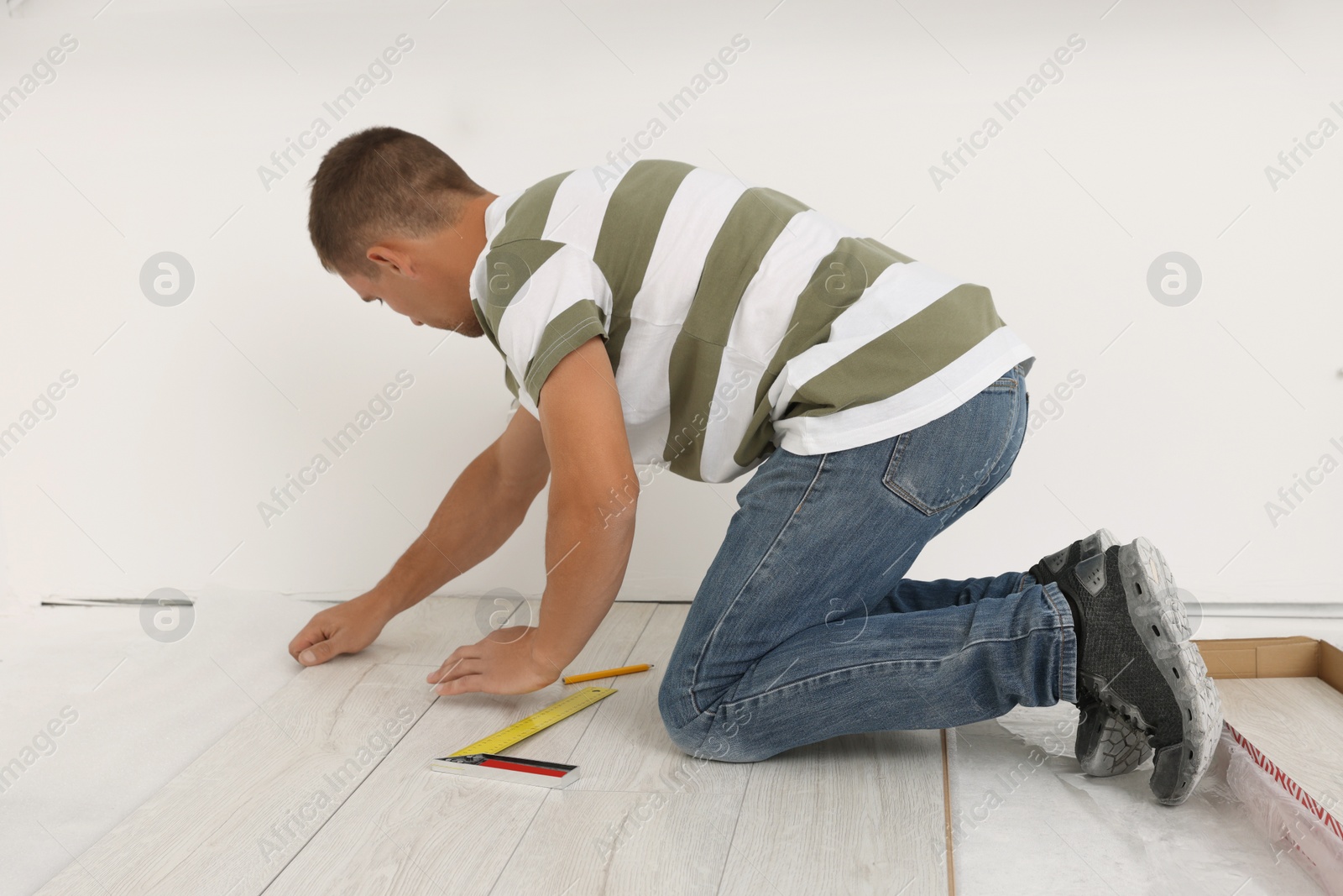 Photo of Professional worker installing new laminate flooring indoors