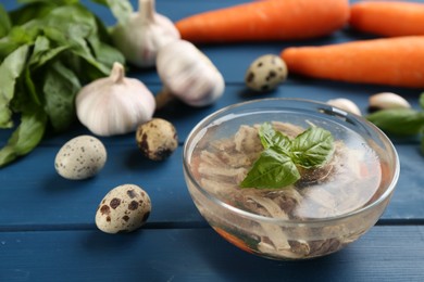 Delicious aspic with meat in bowl on blue wooden table