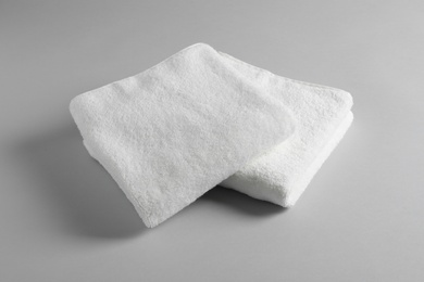 Photo of Fresh soft folded towels on light background