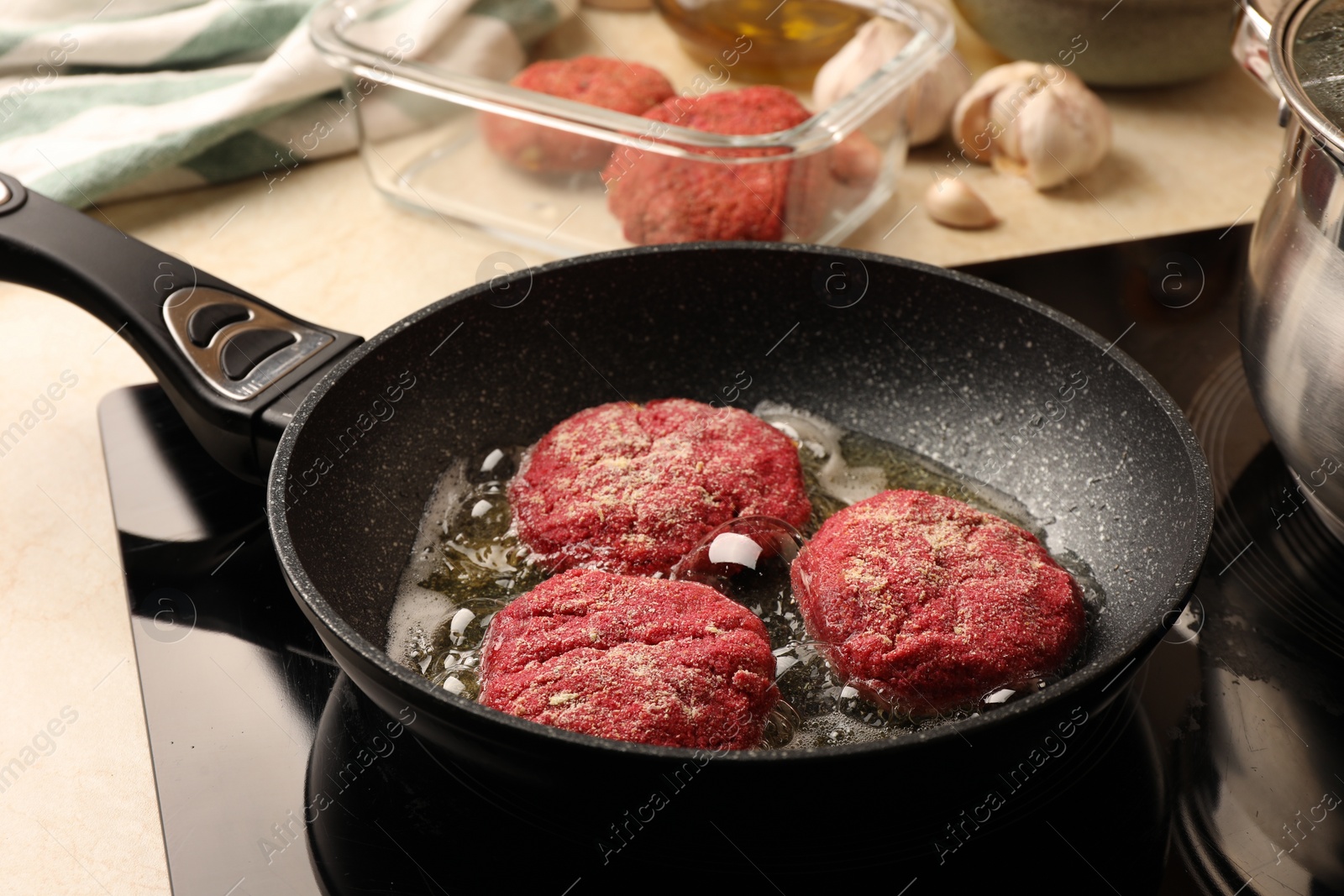 Photo of Cooking vegan cutlets in frying pan on stove, closeup