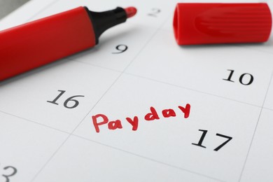 Red felt pen on calendar page with marked payday date, closeup