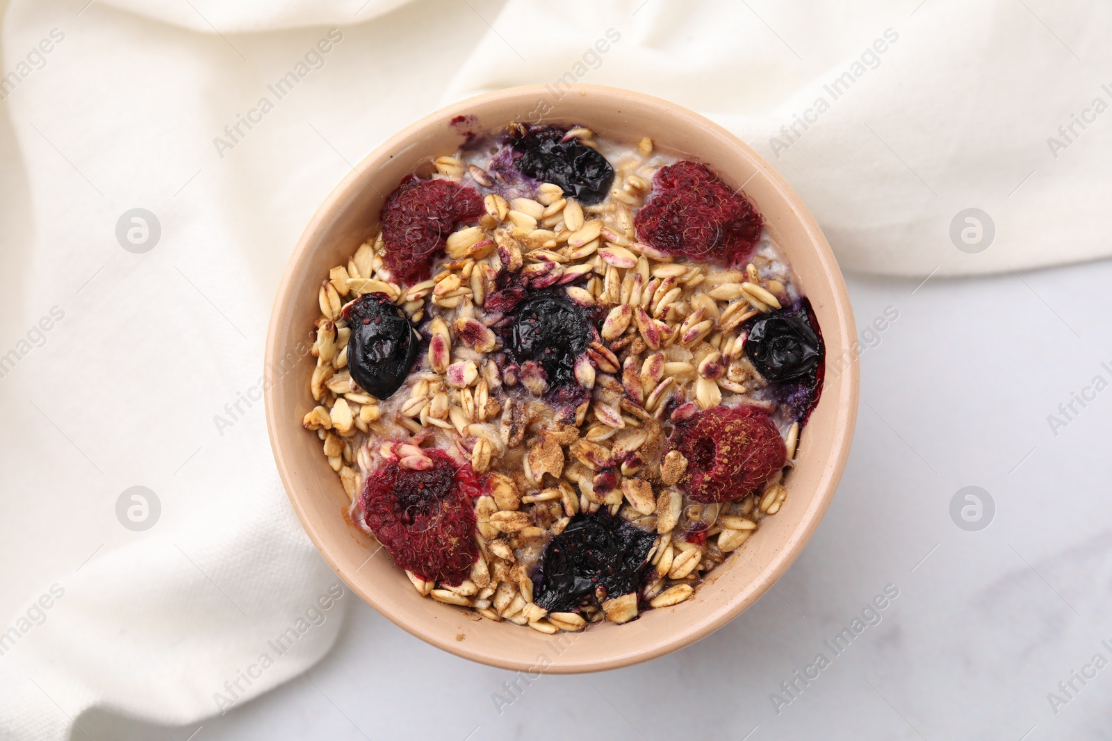 Photo of Tasty baked oatmeal with berries on white table, top view