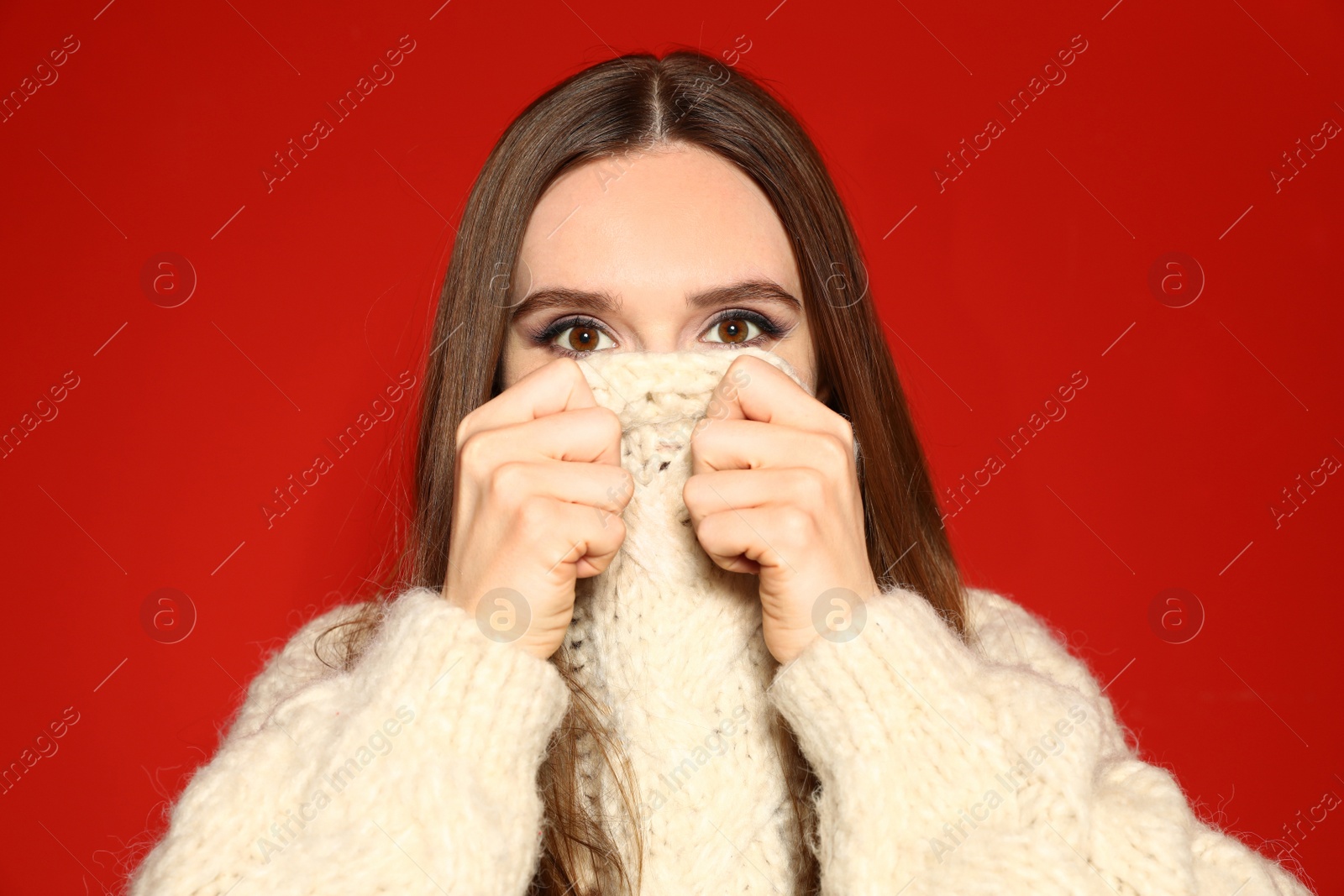 Photo of Young woman wearing Christmas sweater on red background