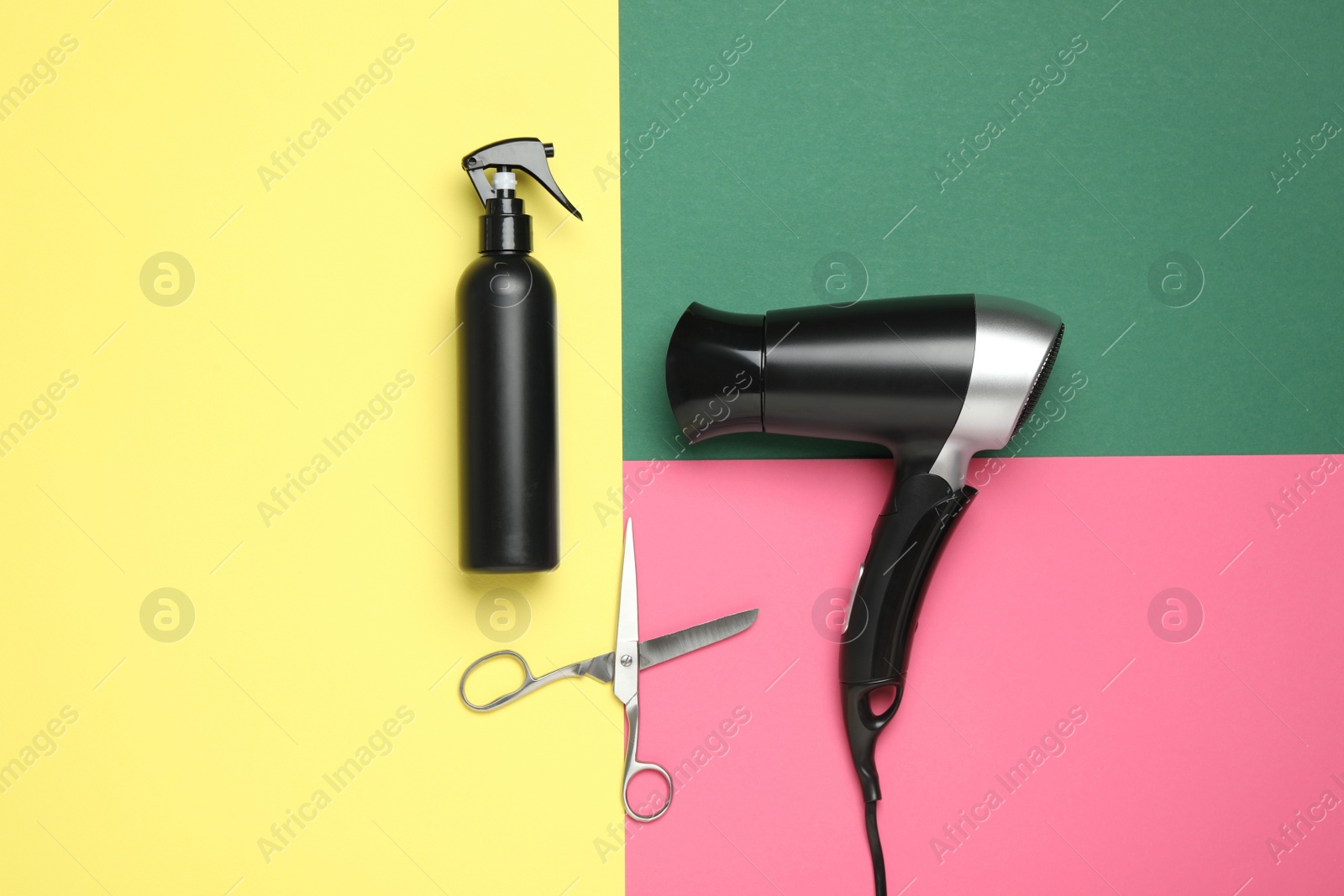 Photo of Hair dryer and professional hairdresser tools on color background, flat lay