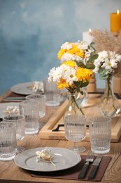 Photo of Elegant festive setting with floral decor on wooden table
