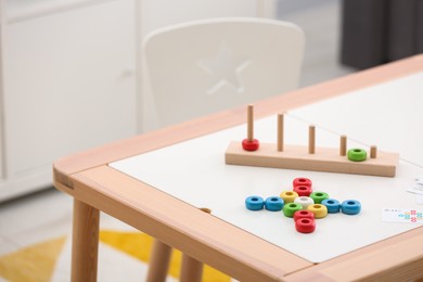 Photo of Stacking and counting game on table indoors, space for text. Educational toy for motor skills development