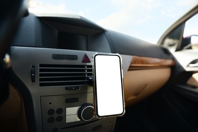 Photo of Holder with modern mobile phone in car. Mockup for design