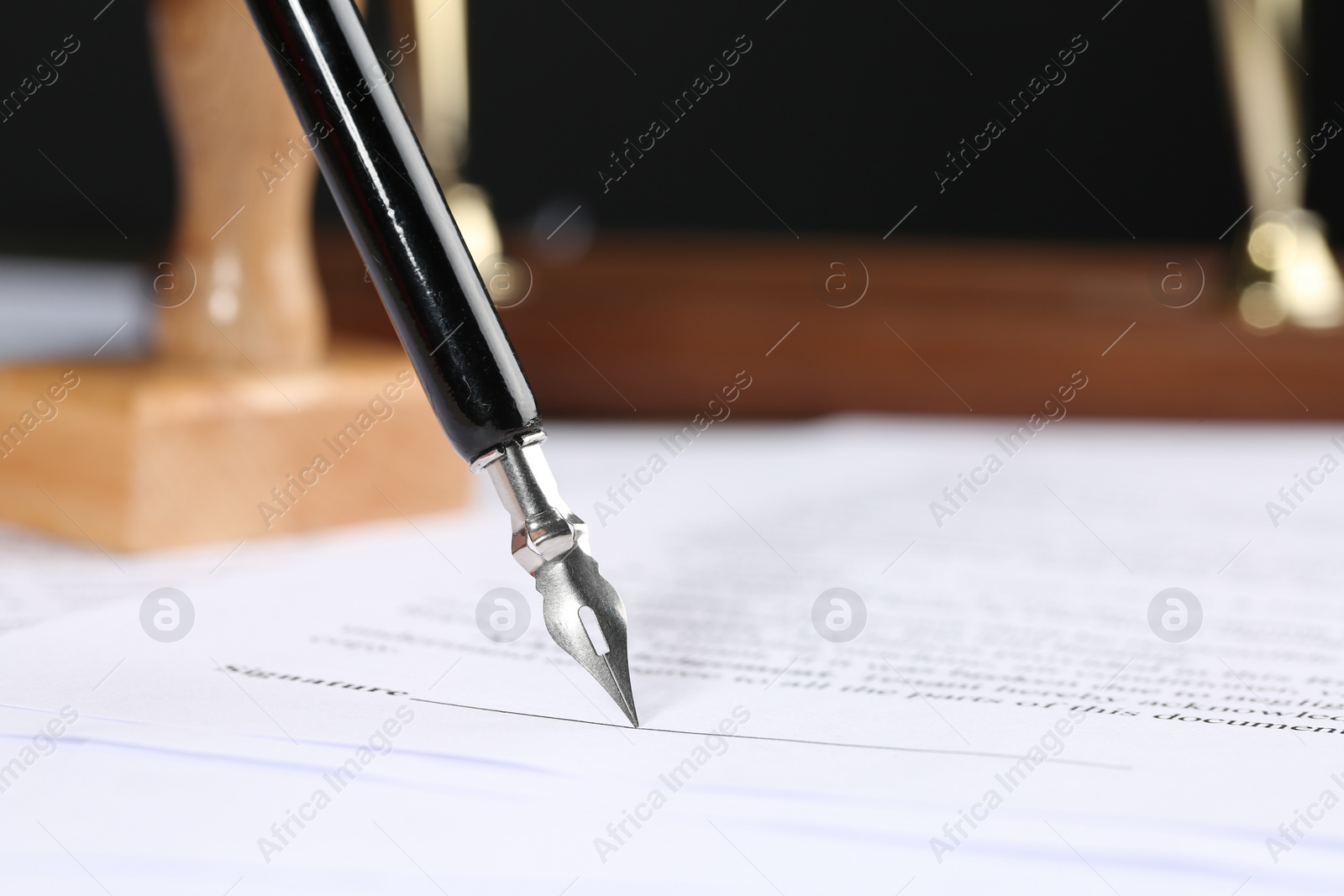 Photo of Signing notary document with fountain pen, closeup