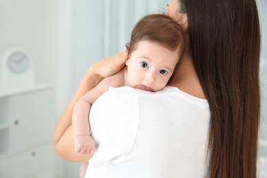 Photo of Woman holding her baby at home, closeup