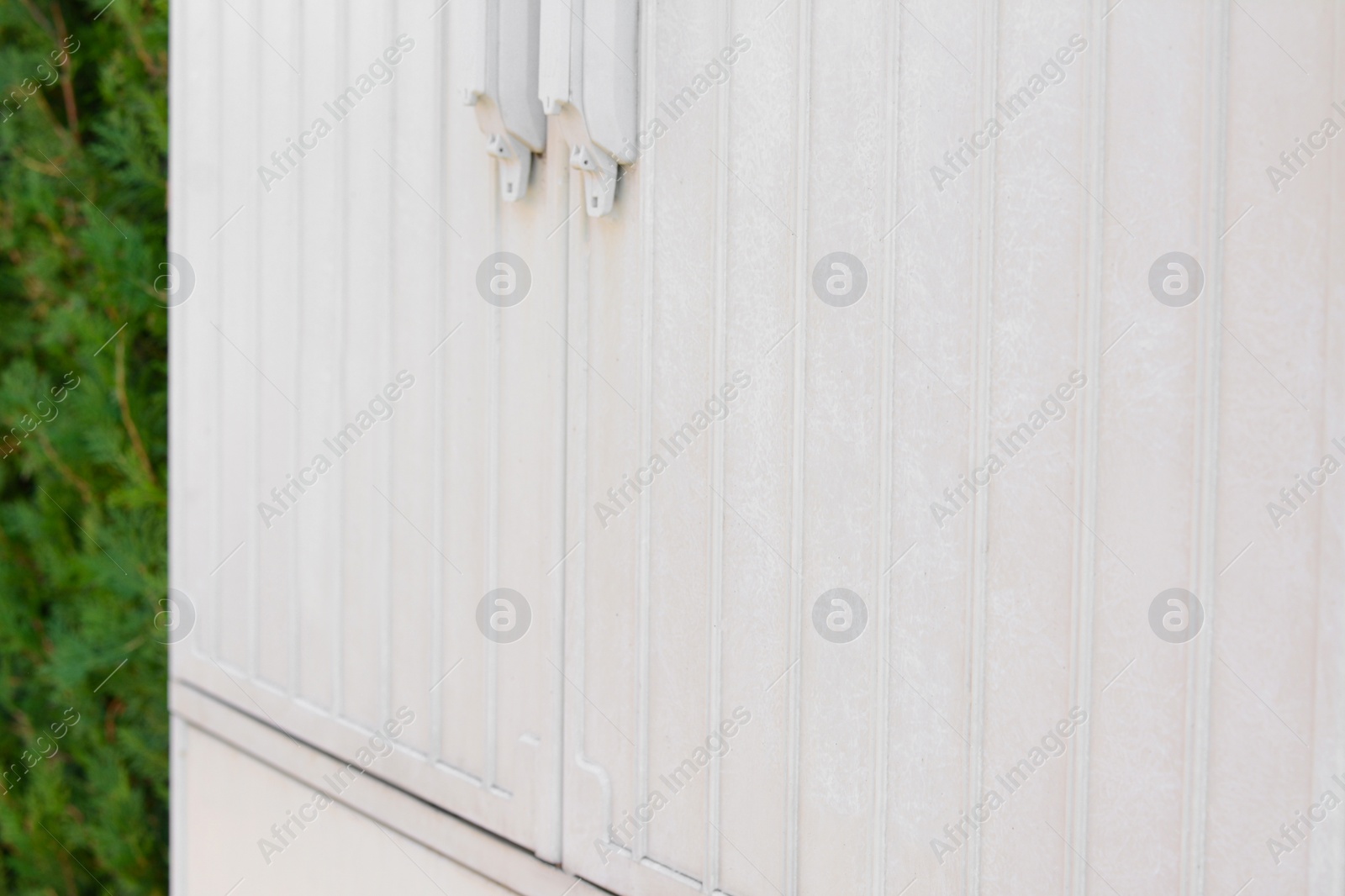 Photo of Electrical power panel near green hedge outdoors, closeup