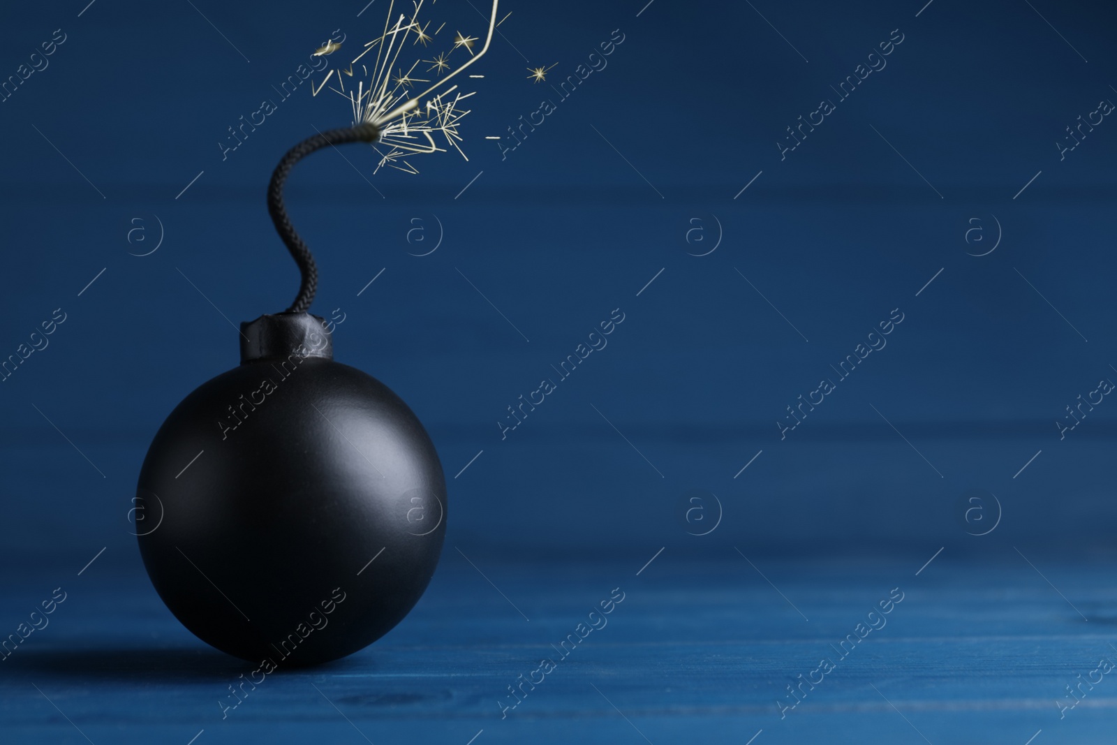 Photo of Old fashioned fuse bomb on blue wooden table. Space for text