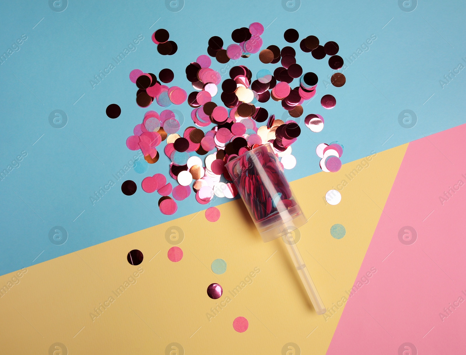 Photo of Party popper with pink confetti on color background, flat lay