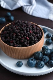Photo of Freeze dried and fresh blueberries on wooden table