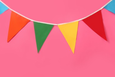 Bunting with colorful triangular flags on pink background