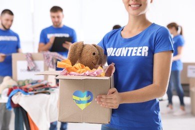 Humanitarian aid for Ukrainian refugees. Volunteer holding box with donations indoors