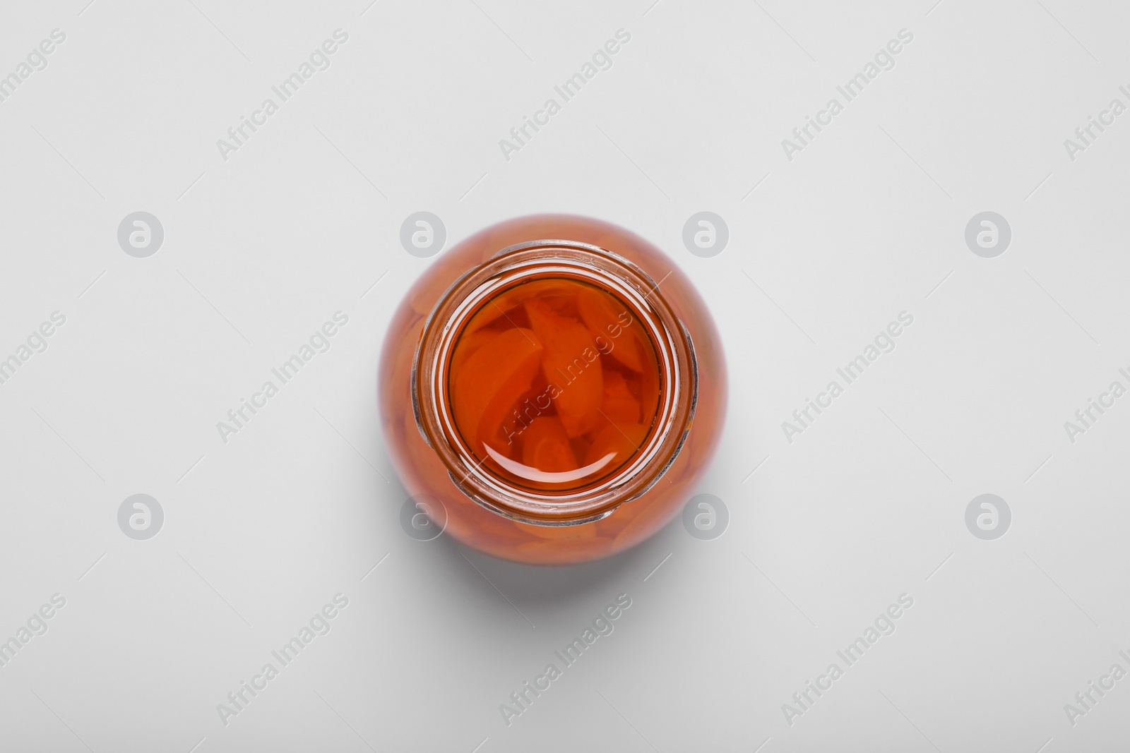 Photo of Tasty canned sliced apricots on white background, top view