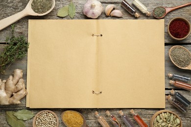 Photo of Blank recipe book surrounded by different ingredients on old wooden table, flat lay. Space for text