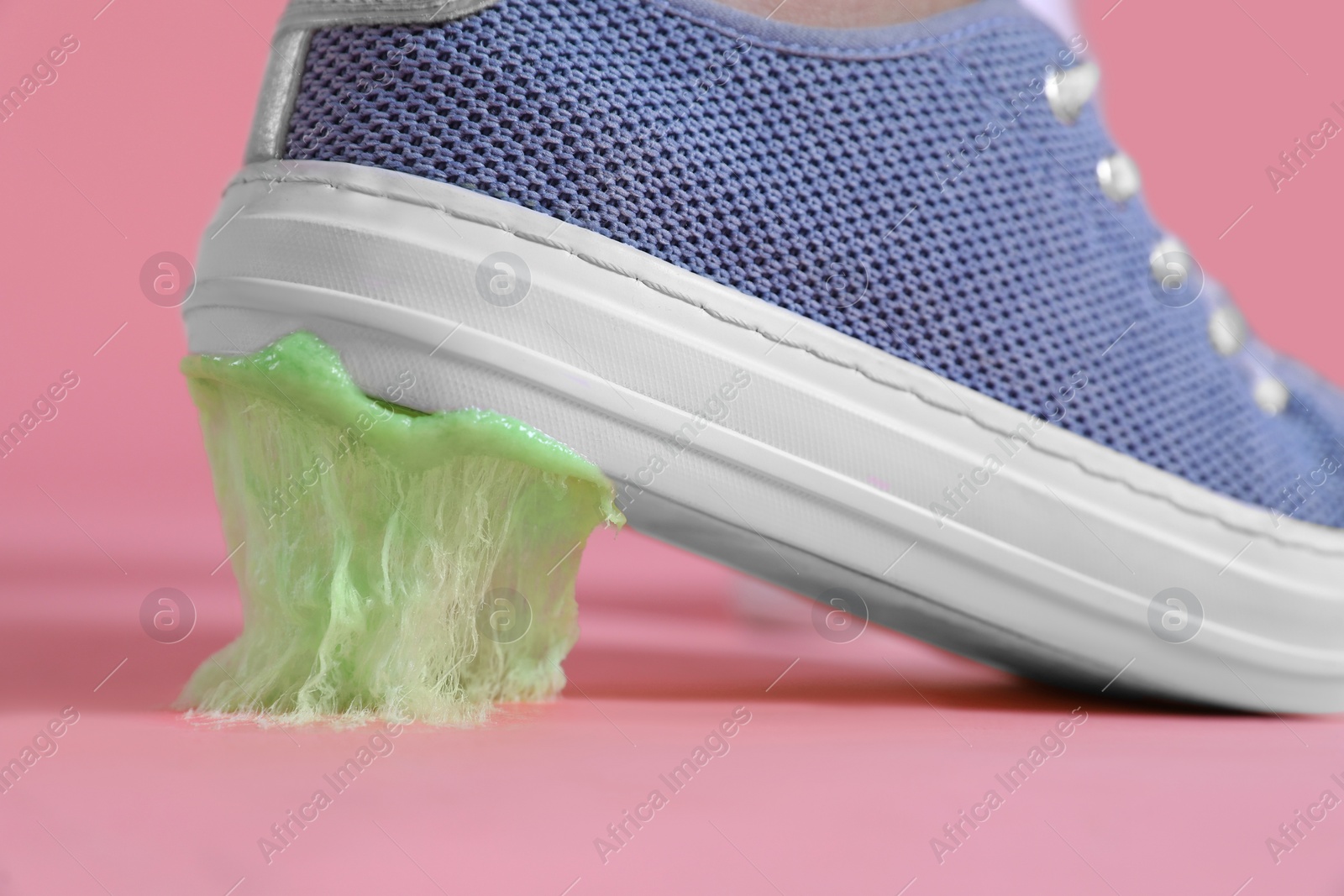 Photo of Person stepping into chewing gum on pink background, closeup