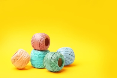 Photo of Different sewing threads on color background