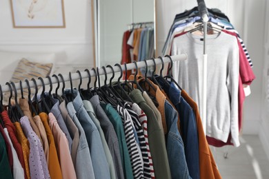 Photo of Racks with stylish clothes indoors. Fast fashion