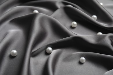 Photo of Many beautiful pearls on delicate black silk, closeup