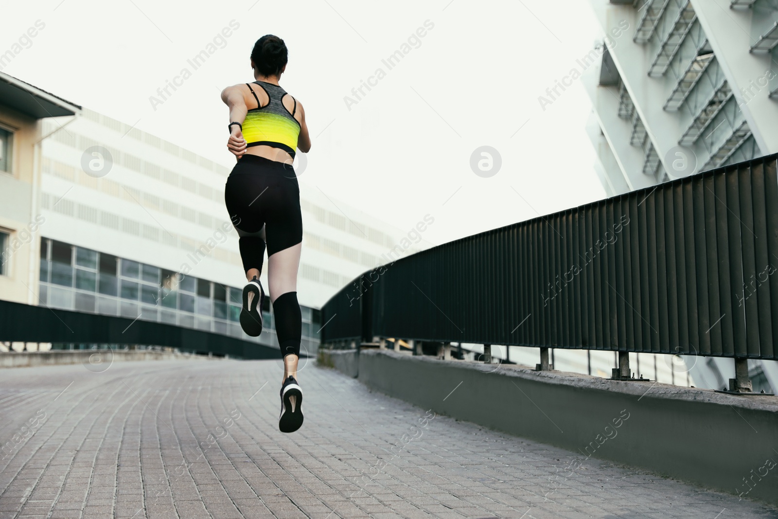 Photo of Beautiful sporty young woman running on street