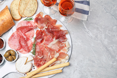 Tasty prosciutto served on light grey marble table, flat lay. Space for text