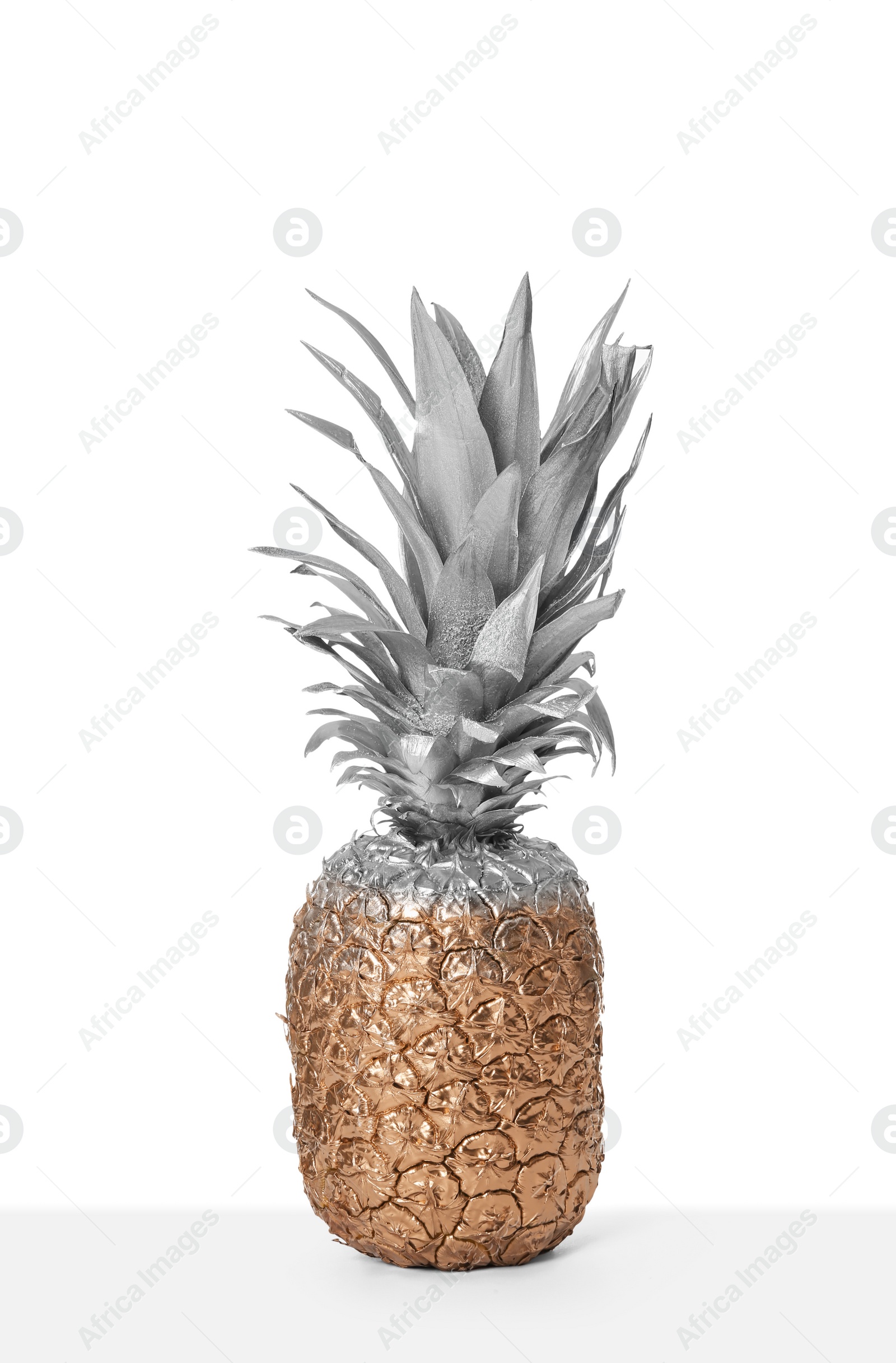 Photo of Pineapple painted with silver and gold on white background