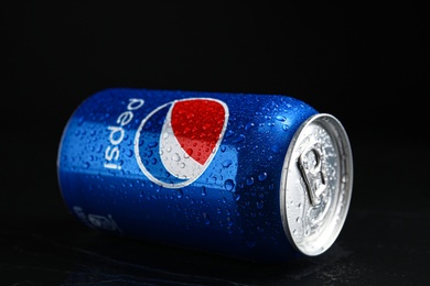 Photo of MYKOLAIV, UKRAINE - FEBRUARY 08, 2021: Can of Pepsi with water drops on black table, closeup