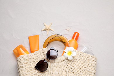 Flat lay composition with sun protection products on sand