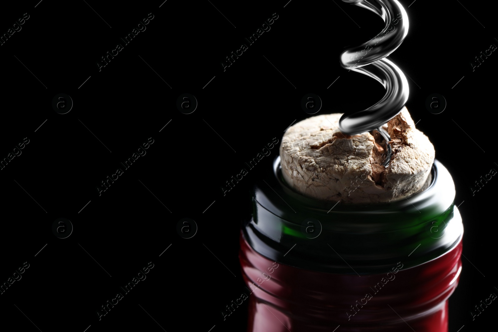 Photo of Opening wine bottle with corkscrew on dark background, closeup. Space for text