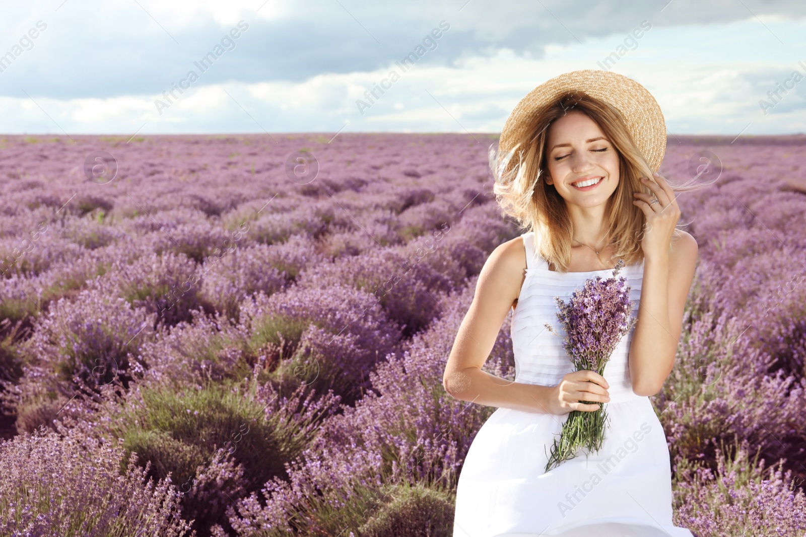 Photo of Young woman with bouquet in lavender field