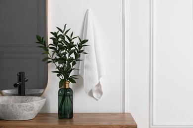 Photo of Stylish mirror over vessel sink and eucalyptus branches on bathroom vanity, space for text. Interior design