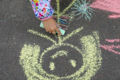 Photo of Child drawing family with chalk on asphalt, closeup