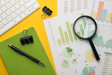 Accounting documents, magnifying glass, computer keyboard and stationery on yellow background, flat lay