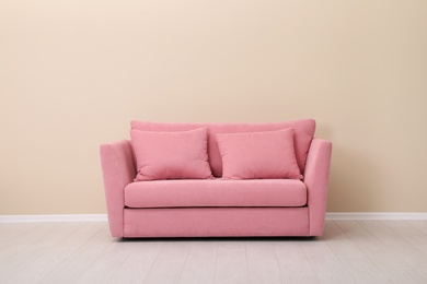 Photo of Room interior with comfortable sofa near color wall