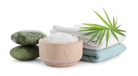 Photo of Bowl of sea salt, towels, massage stones and palm leaf isolated on white. Spa treatment