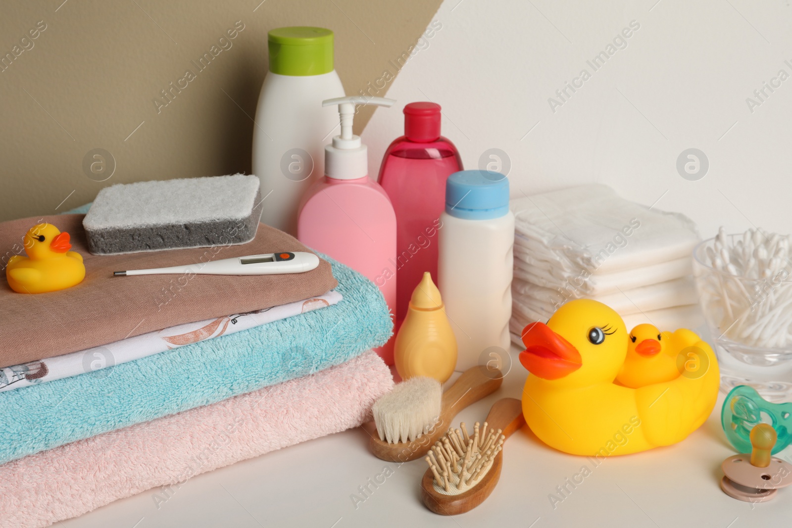 Photo of Towels, toys and baby accessories on white table