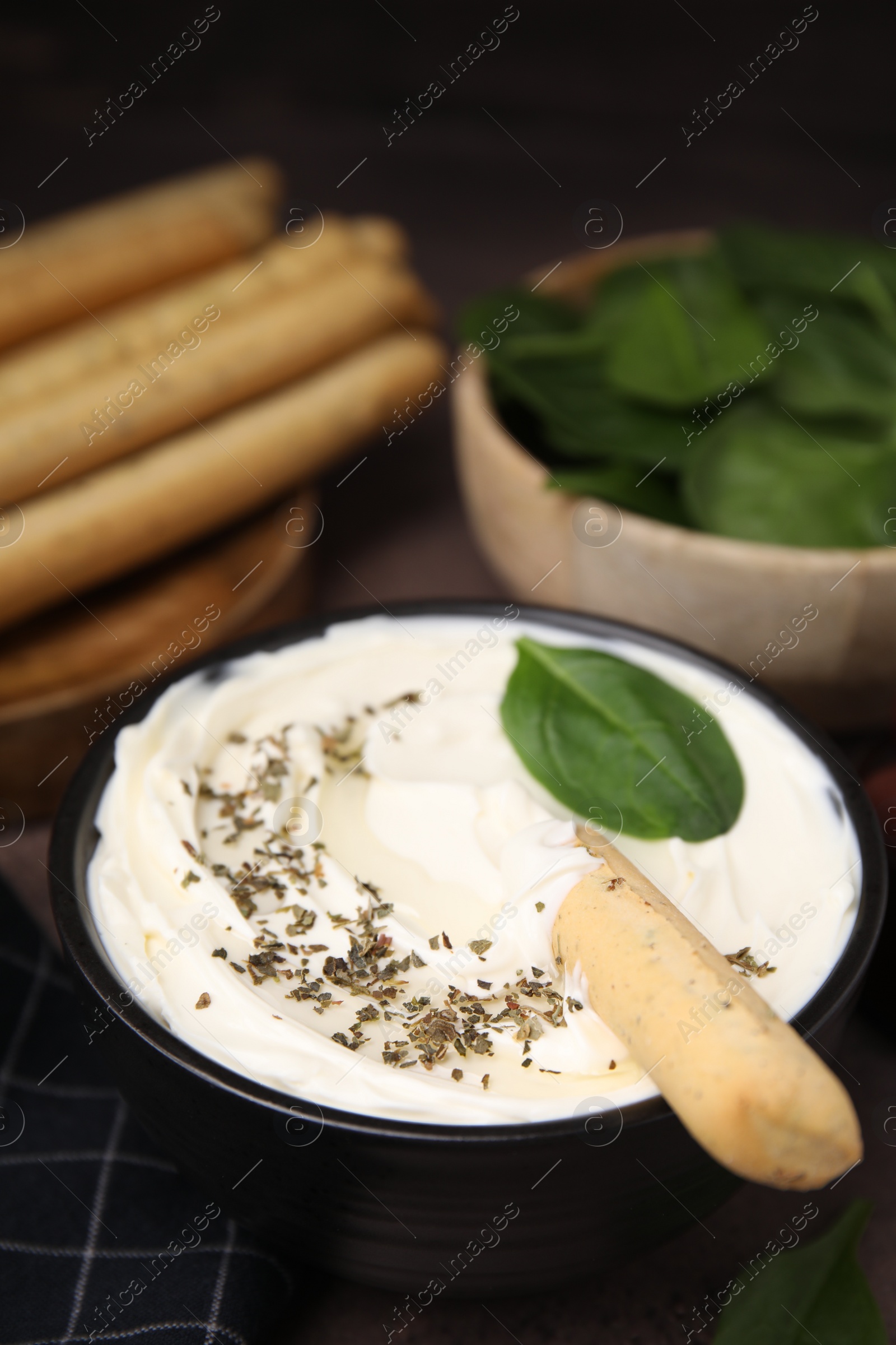 Photo of Delicious cream cheese with grissini stick and spices on table, closeup