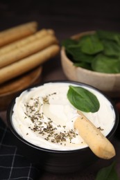 Delicious cream cheese with grissini stick and spices on table, closeup