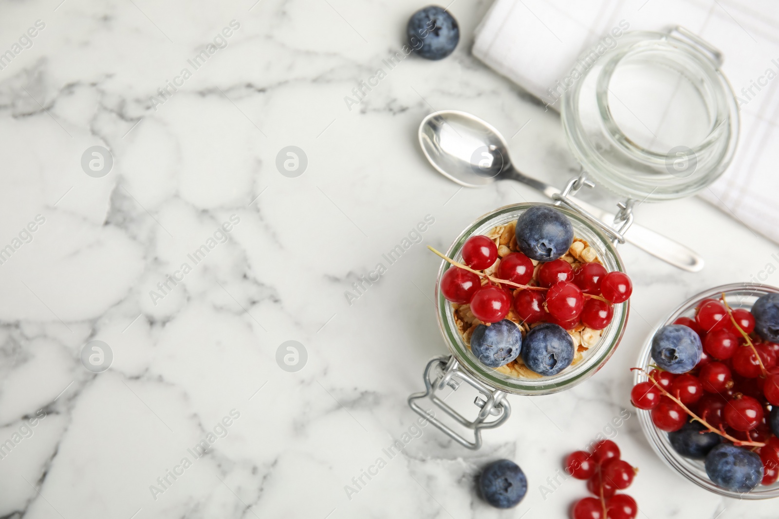 Photo of Delicious yogurt parfait with fresh berries on white marble table, flat lay. Space for text