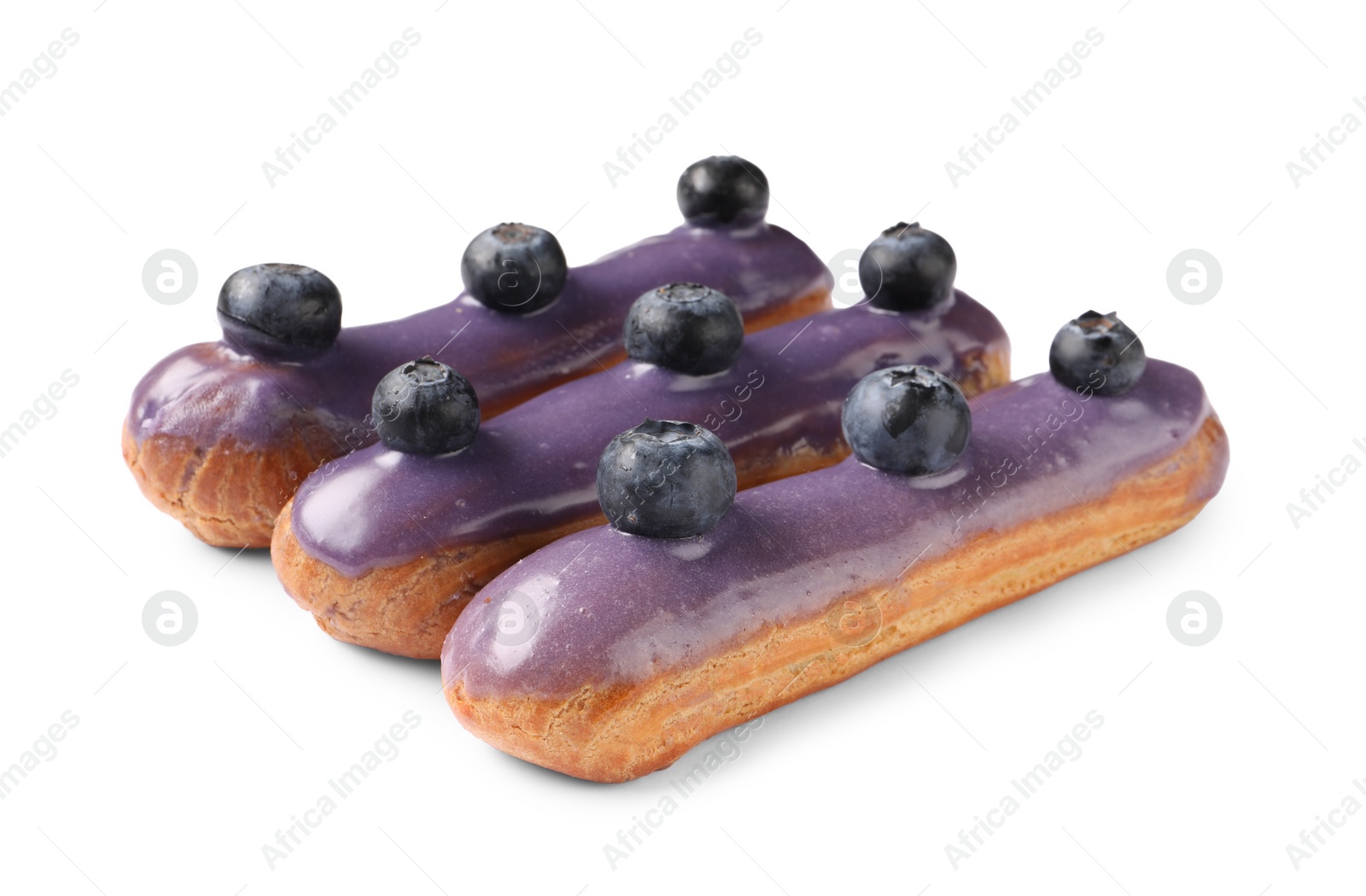 Photo of Delicious eclairs decorated with blueberries isolated on white