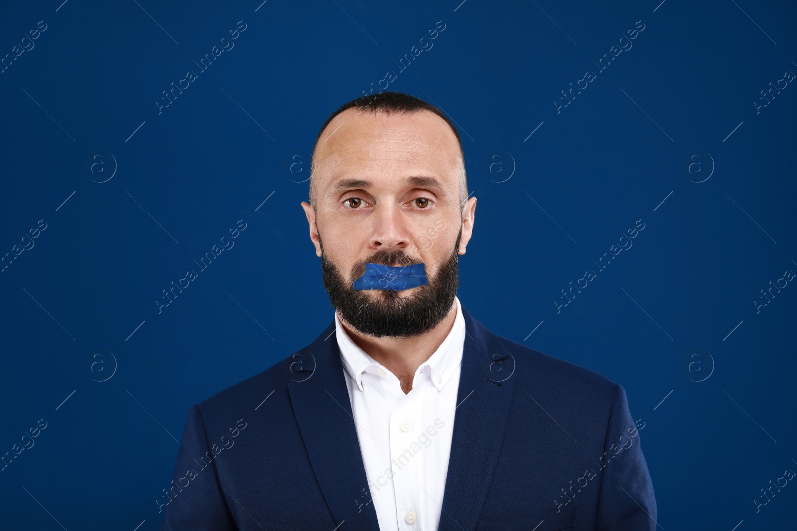 Image of Mature man with taped mouth on blue background. Speech censorship